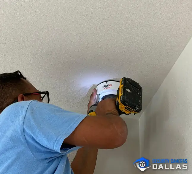 Technician installing a commercial security camera at a Dallas business Technician installing a commercial security camera at a Dallas business