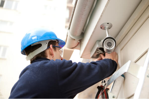 dallas-security-camera-technician-installing-camera-img Dallas security camera company technician installing a camera