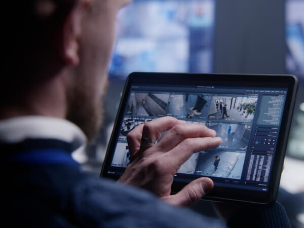 Operator monitoring live video surveillance feeds on a tablet