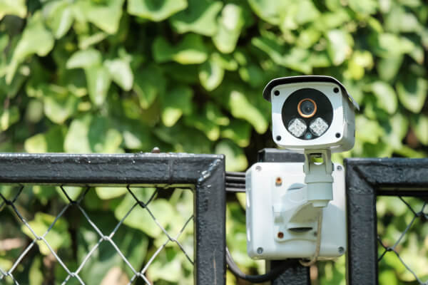 Security cameras and an infrared floodlight on a pole over a property