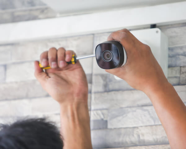 Technician mounting a commercial security camera on a wall