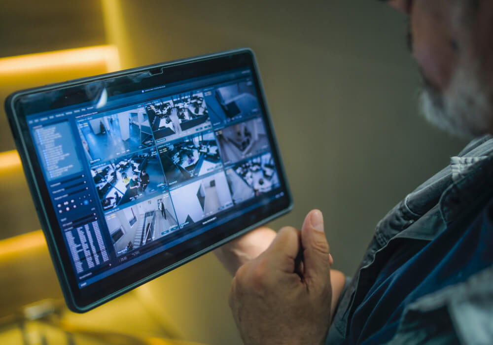 Business owner viewing live multi-camera security footage on a tablet